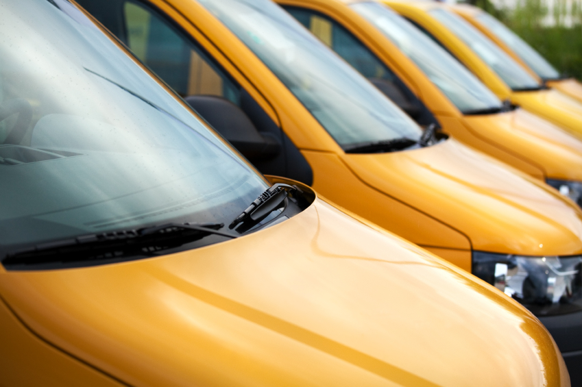 Hoods and windshields of three yellow cars side by side